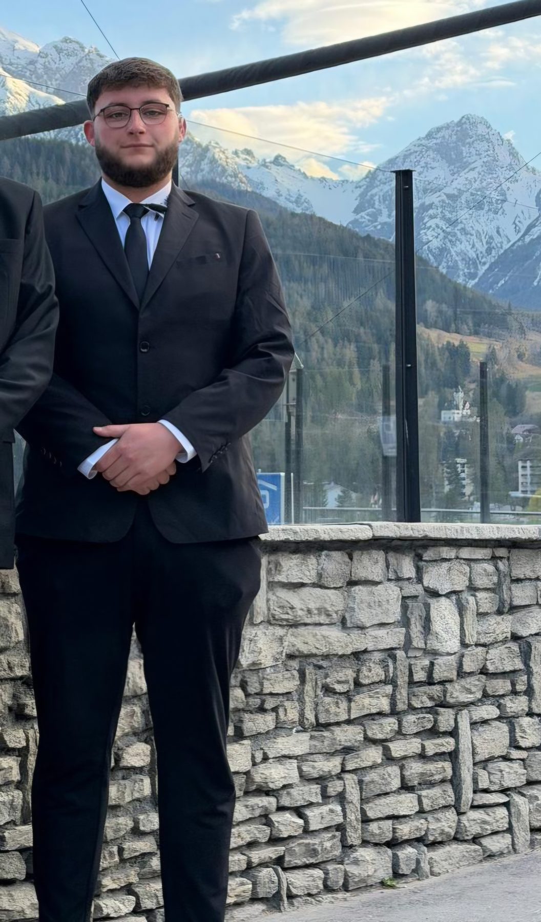 Artur Kloster, Security Project Manager, im Anzug vor Bergkulisse