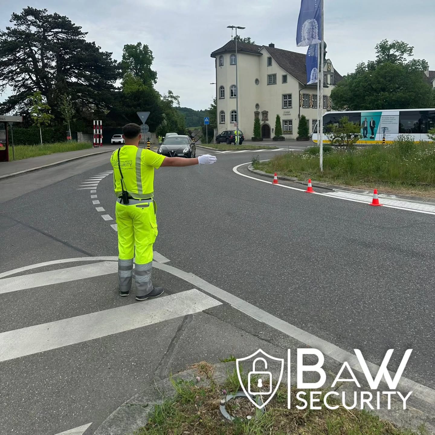 Verkehrsdienstmitarbeiter regelt eine Kreuzung, BaW-Security-Logo im Bild